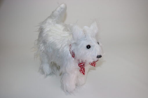Ein süßer weißer Westie steht in Kuscheltiergröße auf dem Boden und man könnte meinen, dass er mit dem Schwanz wedelt